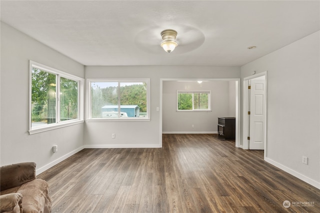 unfurnished living room with dark hardwood / wood-style floors and ceiling fan