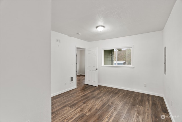 spare room with dark hardwood / wood-style flooring and a textured ceiling