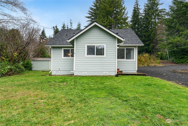 rear view of house featuring a yard