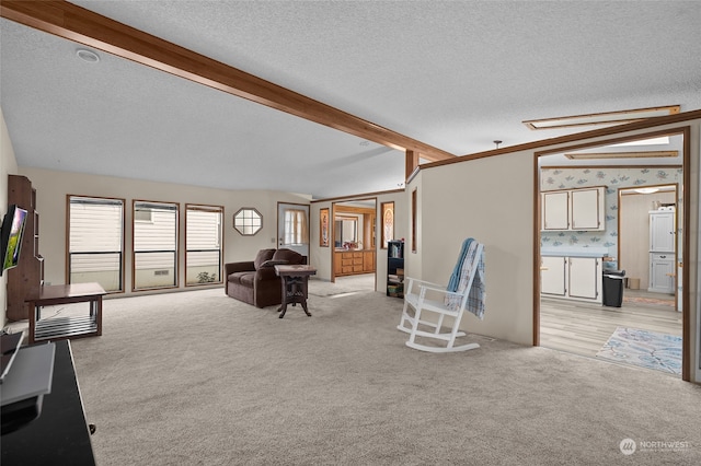 carpeted living room featuring vaulted ceiling with beams and a textured ceiling