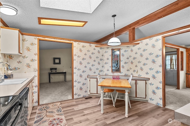 dining area with sink, light hardwood / wood-style floors, a textured ceiling, and ornamental molding