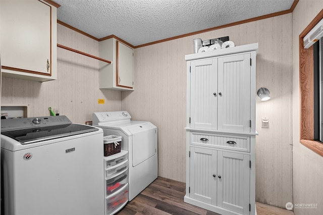 clothes washing area with cabinets, crown molding, dark hardwood / wood-style floors, washer and dryer, and a textured ceiling