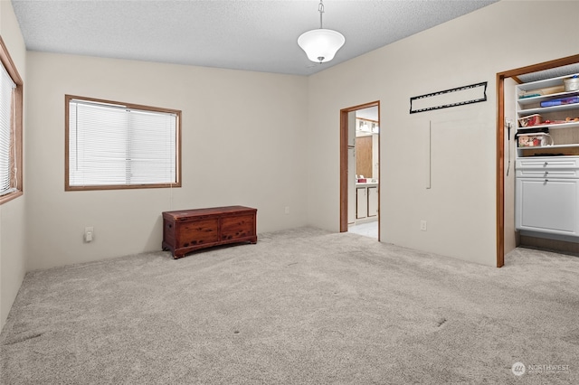 carpeted empty room featuring a textured ceiling and vaulted ceiling