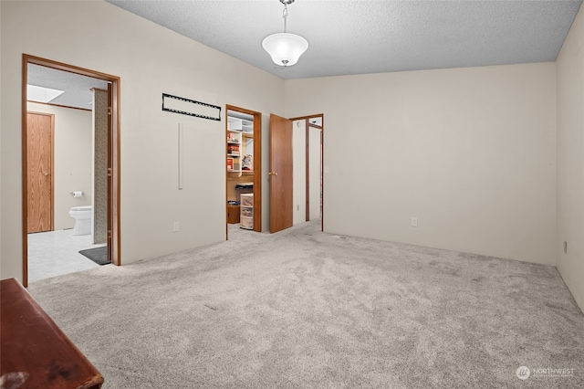 spare room with light colored carpet and a textured ceiling