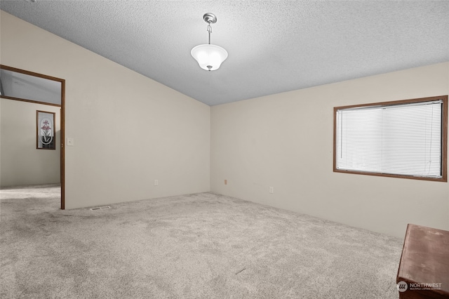 carpeted spare room with a textured ceiling