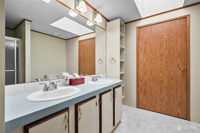 bathroom with crown molding, vanity, a textured ceiling, and toilet