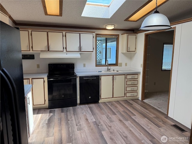 kitchen featuring a sink, light countertops, black appliances, and visible vents