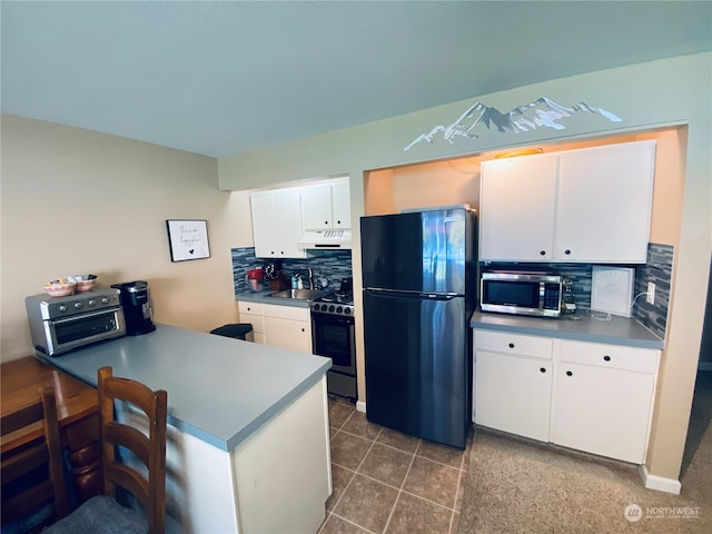 kitchen with white cabinetry, sink, tasteful backsplash, kitchen peninsula, and appliances with stainless steel finishes