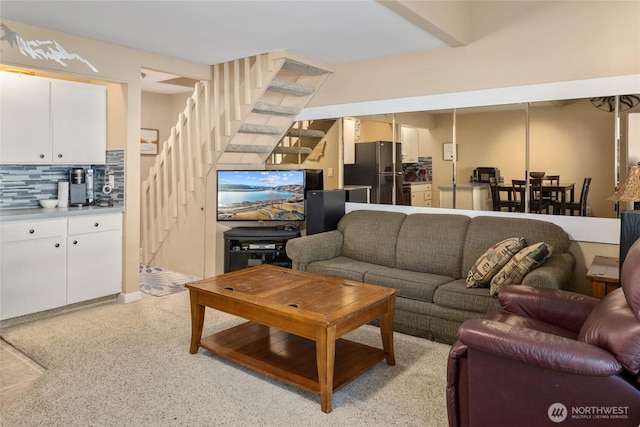 living area featuring stairway and light speckled floor