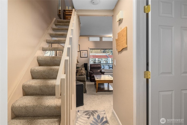 stairway featuring carpet floors and baseboards