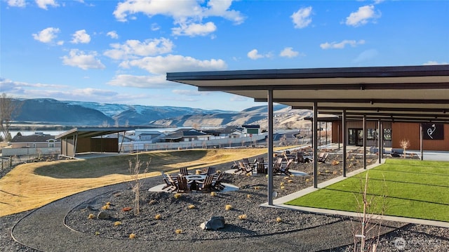 view of yard featuring an outdoor fire pit, fence, and a mountain view