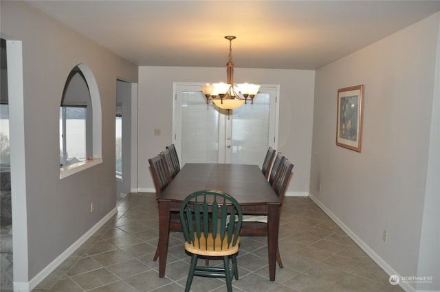 dining space featuring tile patterned floors and a notable chandelier