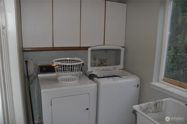 laundry room with washing machine and clothes dryer, sink, and cabinets