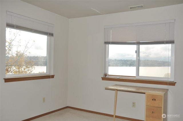 unfurnished room featuring a water view and a wealth of natural light