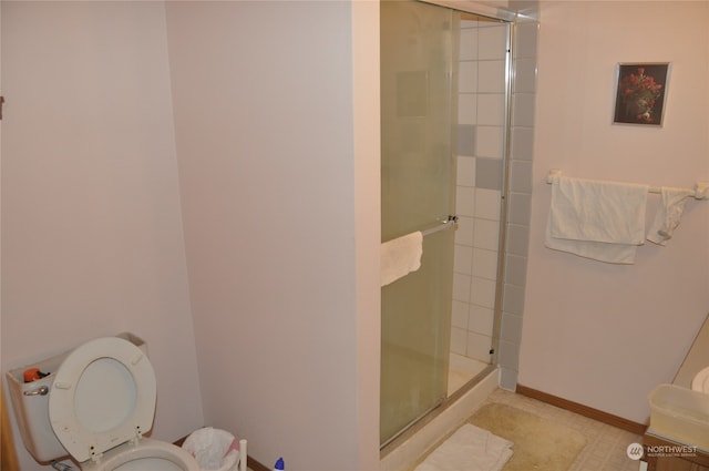 bathroom with toilet and a shower with shower door