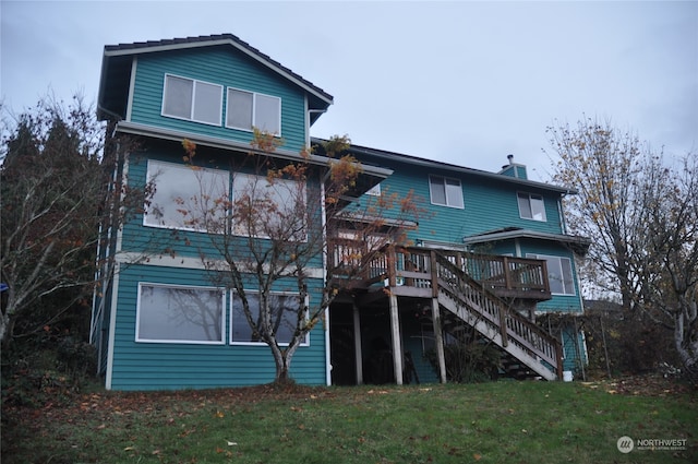 back of property featuring a lawn and a deck