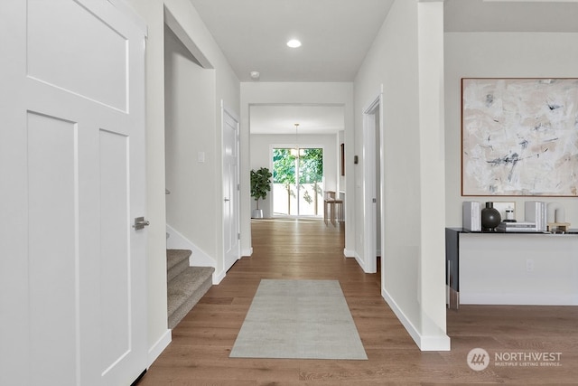 hall with hardwood / wood-style flooring and a chandelier