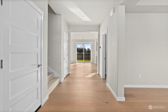 hall featuring a notable chandelier and light hardwood / wood-style floors