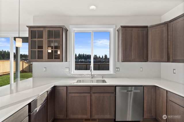 kitchen featuring dark brown cabinetry, sink, tasteful backsplash, decorative light fixtures, and dishwasher