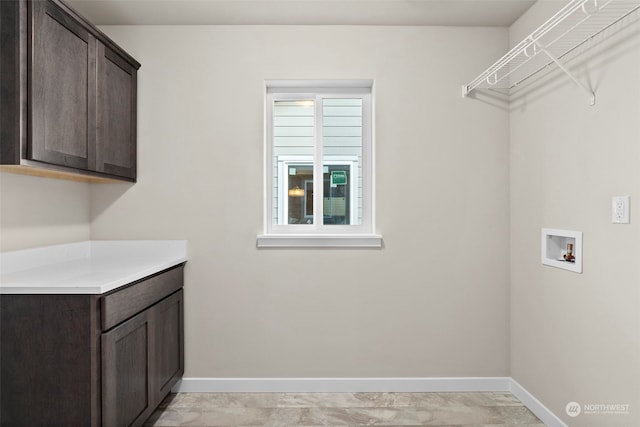 clothes washing area with hookup for a washing machine and cabinets