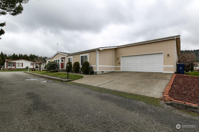 view of front facade featuring concrete driveway, an attached garage, and a residential view