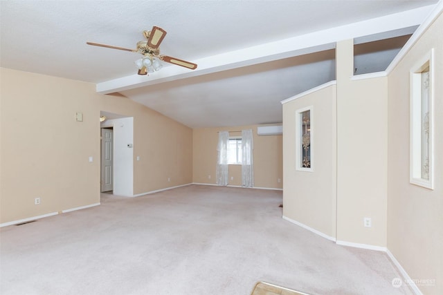 empty room with ceiling fan, light colored carpet, lofted ceiling with beams, and a wall unit AC