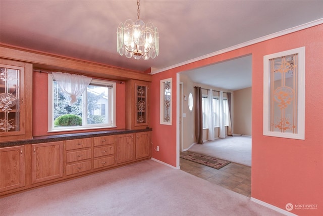 interior space with a notable chandelier, ornamental molding, and light colored carpet