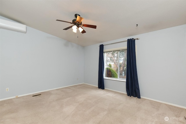 spare room featuring ceiling fan, light colored carpet, and a wall mounted air conditioner