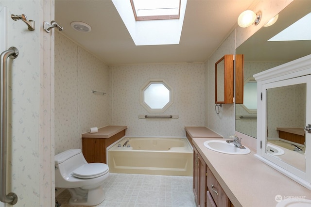 bathroom featuring a tub to relax in, toilet, a skylight, vanity, and tile patterned flooring