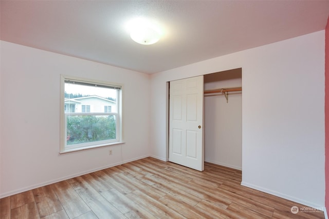 unfurnished bedroom featuring a closet and light wood-type flooring