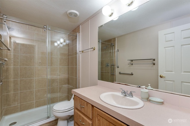 bathroom featuring vanity, a shower with shower door, and toilet