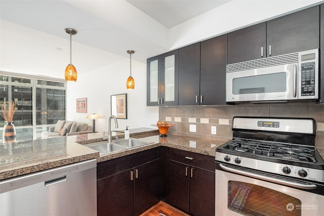 kitchen with appliances with stainless steel finishes, tasteful backsplash, sink, wood-type flooring, and pendant lighting