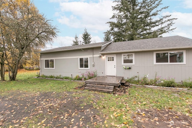 ranch-style home featuring a deck and a front lawn