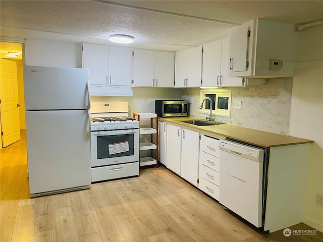 3411 180th Pl Unit 62, Seatac, WA 98188 - kitchen featuring white appliances, a sink, under cabinet range hood, white cabinets, and light wood-type flooring