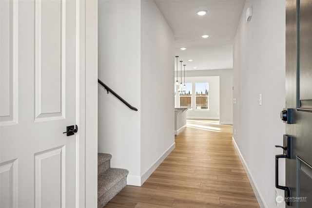 hallway featuring light hardwood / wood-style flooring and a notable chandelier