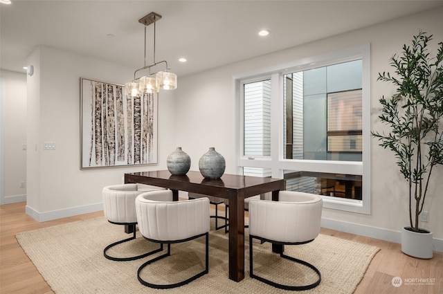 dining area featuring a notable chandelier and light wood-type flooring