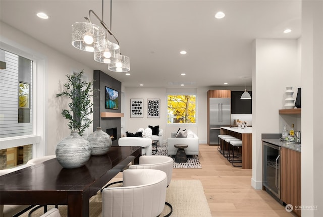 living room with light hardwood / wood-style floors, a fireplace, and beverage cooler