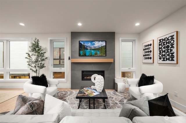 living room with a tile fireplace and hardwood / wood-style floors