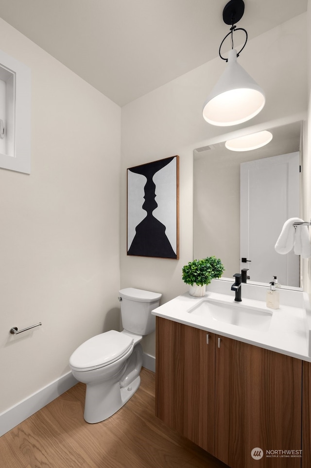 bathroom featuring hardwood / wood-style floors, vanity, and toilet