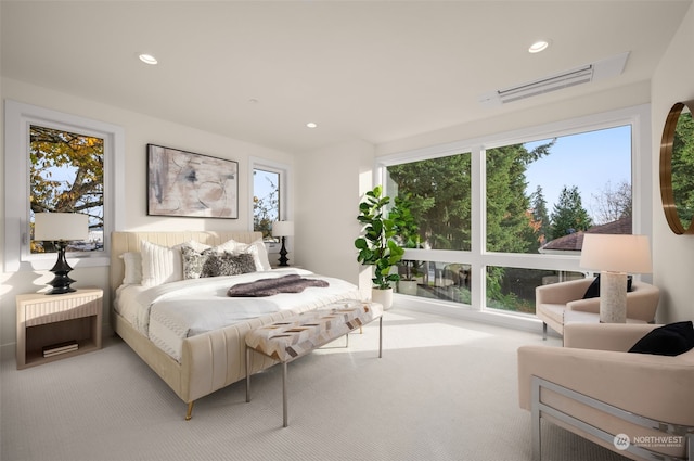 bedroom with light carpet and multiple windows