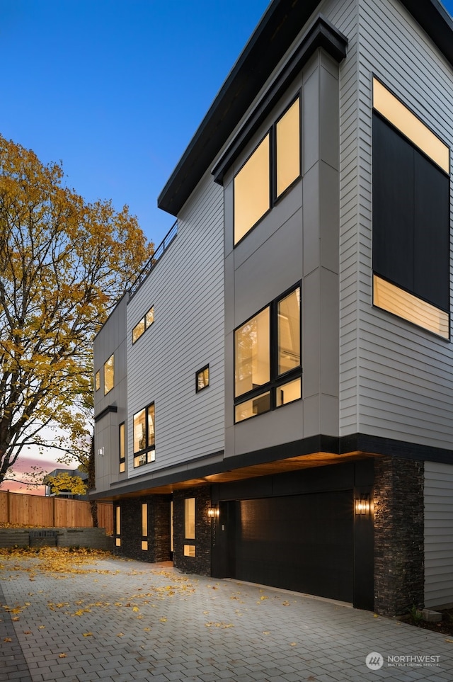 property exterior at dusk featuring a garage