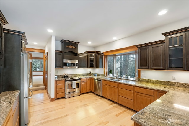 kitchen featuring a healthy amount of sunlight, light hardwood / wood-style flooring, stainless steel appliances, and sink