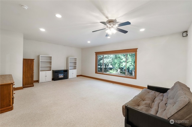 living area featuring light carpet and ceiling fan