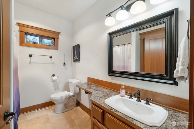 bathroom with tile patterned flooring, vanity, and toilet