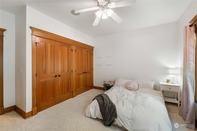 bedroom featuring ceiling fan, light colored carpet, and a closet