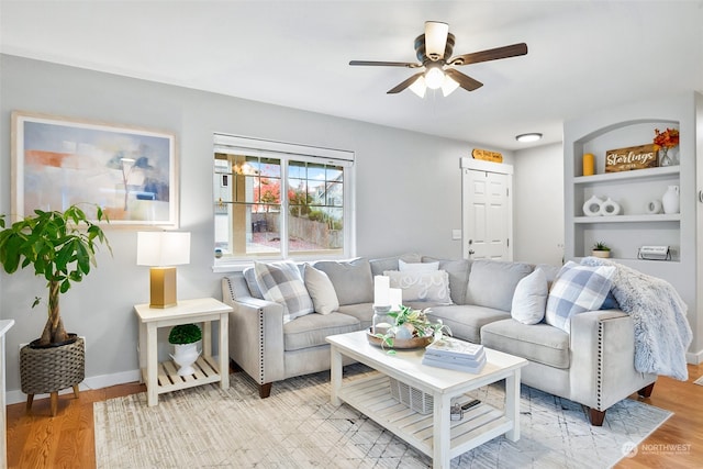 living room with light wood-type flooring and ceiling fan