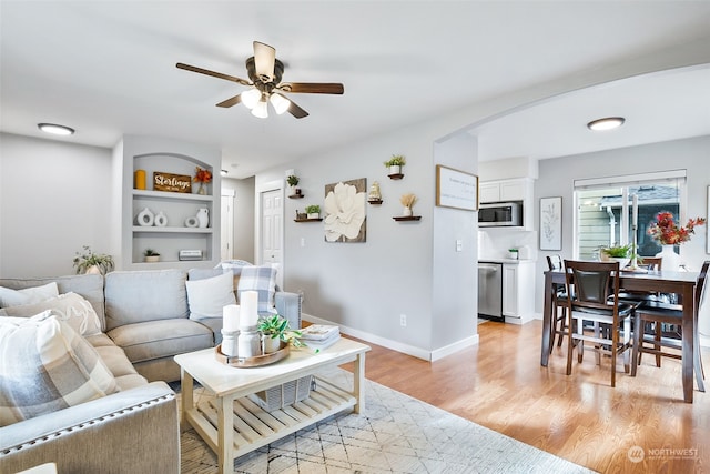 living room with light hardwood / wood-style flooring and ceiling fan