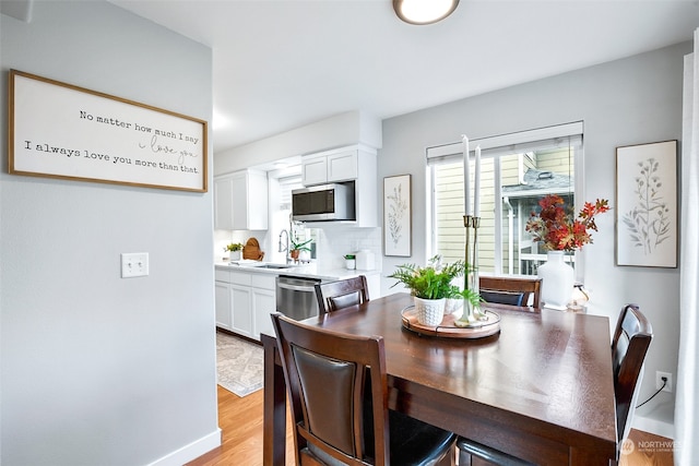 dining room featuring light wood-type flooring and sink