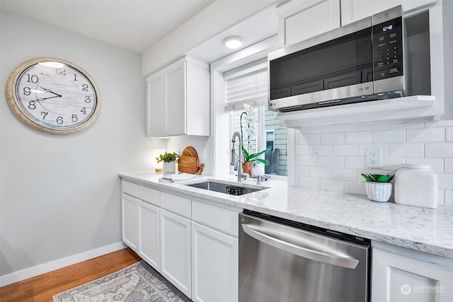 kitchen with white cabinets, sink, appliances with stainless steel finishes, and tasteful backsplash