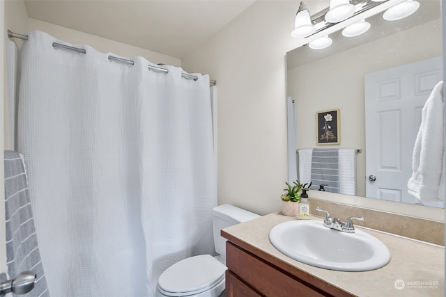 bathroom featuring vanity, curtained shower, and toilet